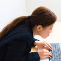 Image of woman using laptop while sitting at her desk